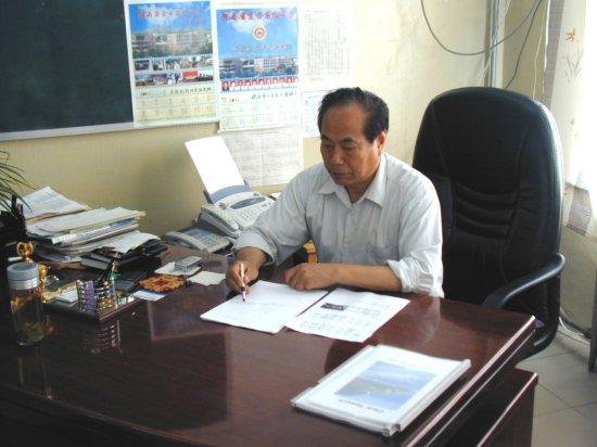 Mr. Yang sits at his Desk