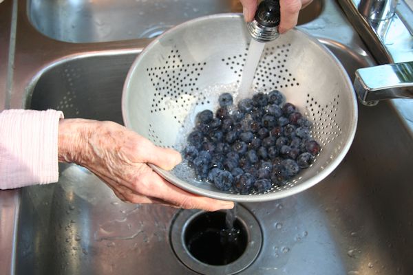 Step 2 - Wash BlueberriesUsing cold water and a colander Bernice washes the blueberries. She puts the washed berries in a 4 cup measuring dish. 